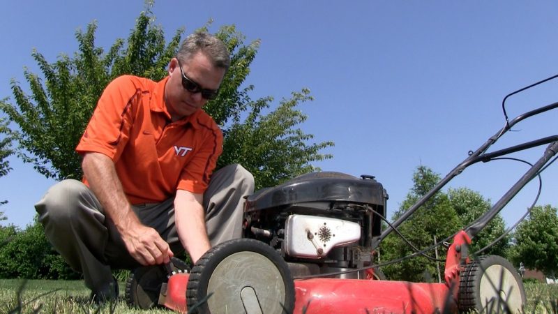 Shawn Askew, Extension Turfgrass Weed Specialist at Virginia Tech, adjust a blade on a lawn mower to help homeowners properly mow their lawns.